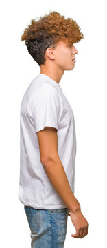 Young handsome man with afro hair wearing casual white t-shirt looking to side, relax profile pose with natural face with confident smile.