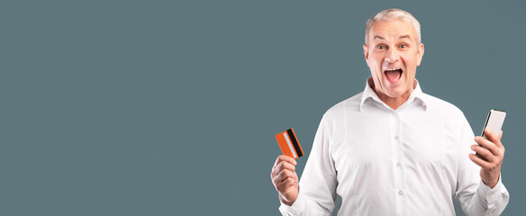Easy Payments. Happy adult man holding credit card and smartphone in his hands, free space