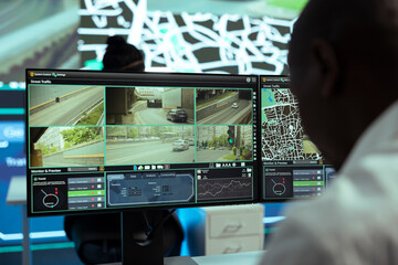 African american operator monitoring traffic on streets and locating couriers, tracking parcels to...