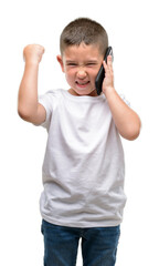 Dark haired little child using a smartphone annoyed and frustrated shouting with anger, crazy and yelling with raised hand, anger concept