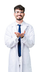 Young professional scientist man wearing white coat over isolated background Smiling with hands palms together receiving or giving gesture. Hold and protection