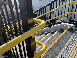 Bright yellow handrails, railings and non-slip stairs on new staircase at railway station