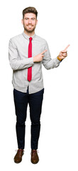 Young handsome business man smiling and looking at the camera pointing with two hands and fingers to the side.