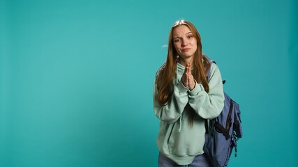 Woman doing begging hand gesture, in ardent need of favor from friend, isolated over studio background. Young girl doing please gesturing, requesting assistance, camera B