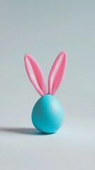 Obraz premium Whimsical Easter egg with pink bunny ears: a playful twist on tradition. Turquoise egg-shaped base topped with soft pink rabbit ears against a light background.