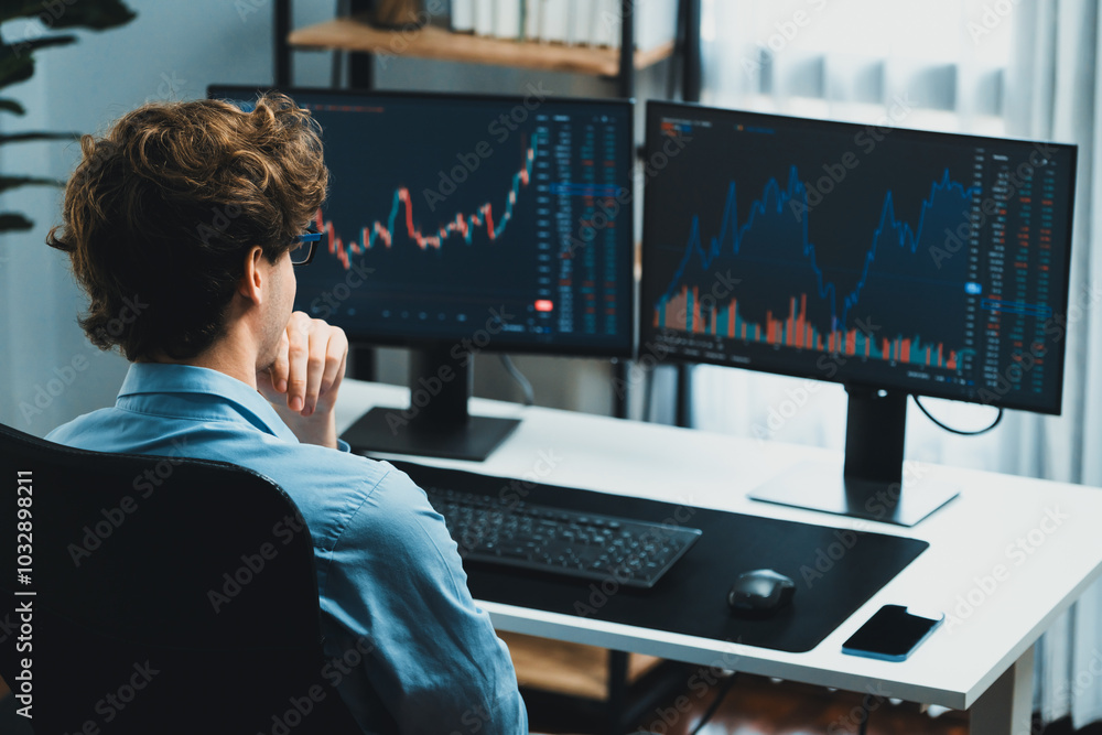 Poster working young business trader focusing on market stock dynamic graph data in real time two pc screen