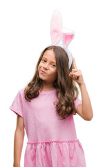 Brunette hispanic girl wearing easter rabbit ears surprised with an idea or question pointing finger with happy face, number one