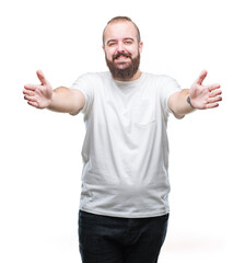 Young caucasian hipster man wearing casual t-shirt over isolated background looking at the camera smiling with open arms for hug. Cheerful expression embracing happiness.