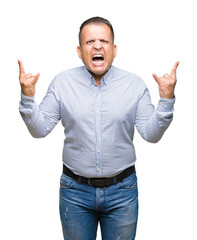 Naklejka premium Middle age arab business man over isolated background shouting with crazy expression doing rock symbol with hands up. Music star. Heavy concept.