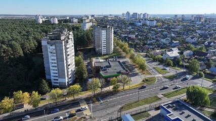 Minsk, Belarus - 27.10.2024: Dense building of a modern large Belarusian city. Neighborhood of one-storey huts, cottages and multi-storey residential buildings. View of the city of Minsk from a height