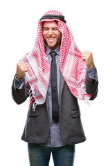 Young handsome arabian man with long hair wearing keffiyeh over isolated background very happy and excited doing winner gesture with arms raised, smiling and screaming for success. Celebration concept