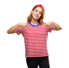 Young beautiful woman over isolated background looking confident with smile on face, pointing...