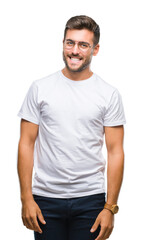 Fototapeta premium Young handsome man wearing glasses over isolated background looking away to side with smile on face, natural expression. Laughing confident.