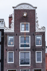 Colorful old buildings with gable rooftops and hooks along Herengracht canal. In XVII century...