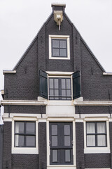 Colorful old buildings with gable rooftops and hooks along Herengracht canal. In XVII century richest merchants, most influential regents and mayors lived on this canal. Amsterdam, the Netherlands.