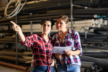 Women having conversation while making stock control, verifying documents and making pointing...