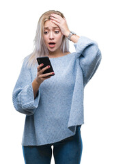 Young blonde woman texting sending message using smartphone over isolated background stressed with...