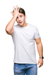Young handsome man wearing white t-shirt over isolated background surprised with hand on head for mistake, remember error. Forgot, bad memory concept.