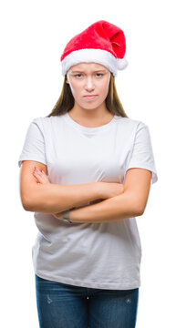 Young beautiful caucasian woman wearing christmas hat over isolated background skeptic and nervous, disapproving expression on face with crossed arms. Negative person.