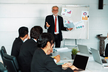 Senior leader speaker speaks to public people audience in training workshop or conference. Mature lecturer is CEO executive manager leading symposium event. International business seminar concept. uds