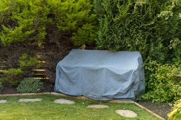 Covered two seat bench set outdoor furniture in garden ready for winter
