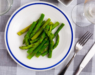Boiled green asparagus is served in bowl for soup, main courses and as independent dish. Vegetable...