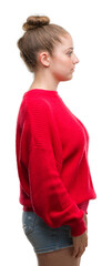 Young blonde woman wearing bun and red sweater looking to side, relax profile pose with natural face with confident smile.