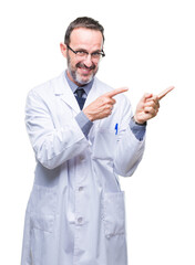 Middle age senior hoary professional man wearing white coat over isolated background smiling and looking at the camera pointing with two hands and fingers to the side.