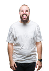 Fototapeta premium Young caucasian hipster man wearing casual t-shirt over isolated background sticking tongue out happy with funny expression. Emotion concept.