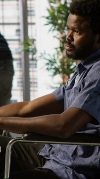 Vertical video Software technician with disability in inclusive workplace working with machine learning tech. African american IT expert with paraplegia in wheelchair transforms data into predictive