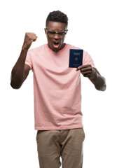 Young african american man holding german passport annoyed and frustrated shouting with anger, crazy and yelling with raised hand, anger concept