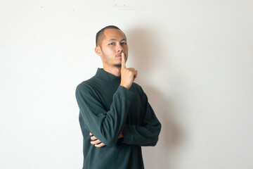 Young men wearing sweater gesturing silent on isolated white background