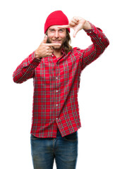 Young handsome man with long hair wearing red cap over isolated background smiling making frame with hands and fingers with happy face. Creativity and photography concept.