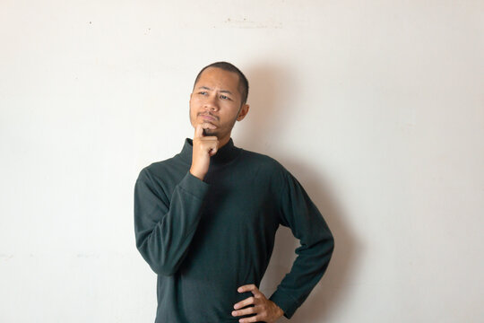 Young men wearing warm clothes is thingking something on isolated white background