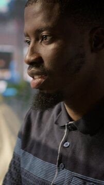 Vertical video System administrator doing software quality assurance, checking source code on tablet. Close up of african american IT specialist at work inspecting coding on device, looking to fix