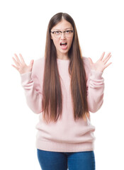 Young Chinese woman over isolated background wearing glasses crazy and mad shouting and yelling with aggressive expression and arms raised. Frustration concept.