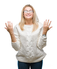 Young caucasian woman wearing glasses over isolated background celebrating mad and crazy for success with arms raised and closed eyes screaming excited. Winner concept