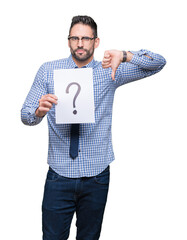 Handsome young business man holding paper with question mark over isolated background with angry...