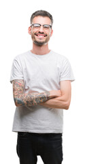 Young tattooed adult man happy face smiling with crossed arms looking at the camera. Positive...