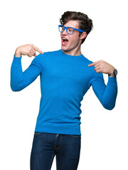 Fototapeta premium Young handsome man wearing blue glasses over isolated background looking confident with smile on face, pointing oneself with fingers proud and happy.