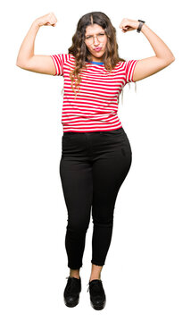 Young beautiful woman wearing glasses showing arms muscles smiling proud. Fitness concept.