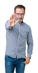 Handsome middle age elegant senior business man wearing glasses over isolated background doing stop sing with palm of the hand. Warning expression with negative and serious gesture on the face.