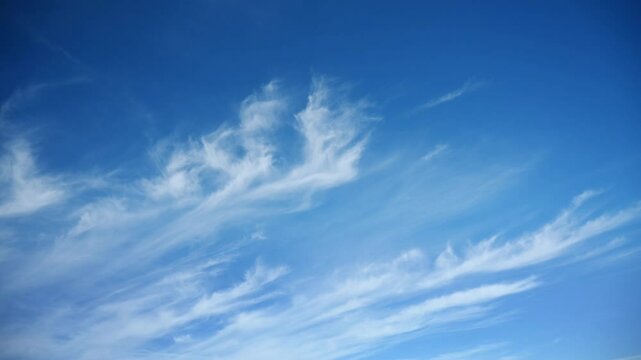 Time lapse of white cirrus clouds moving across a blue sky. Only the sky in the frame.
