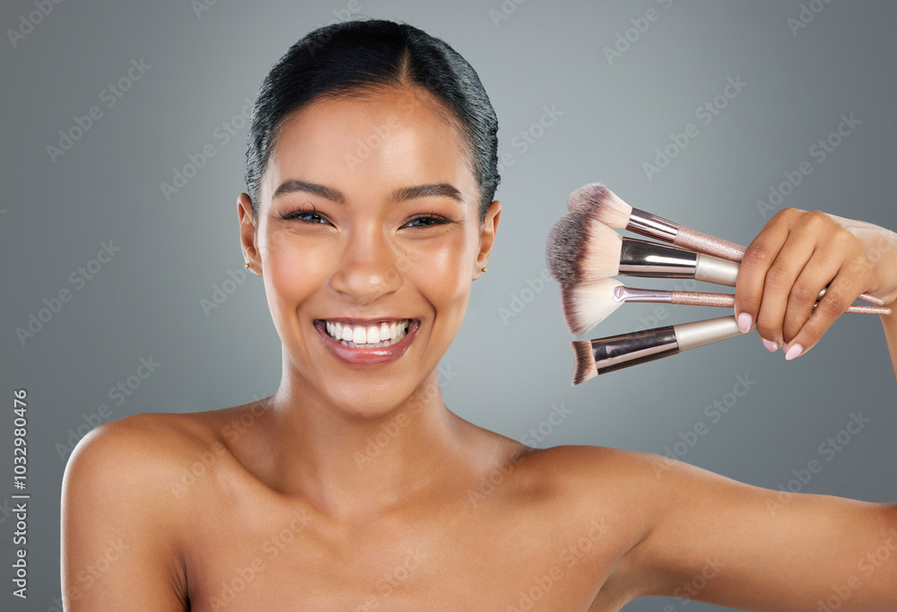 Poster Happy woman, portrait and beauty with makeup brushes for cosmetics or facial on a gray studio background. Young, female person or model with smile, utensils or tools for beautician or makeover