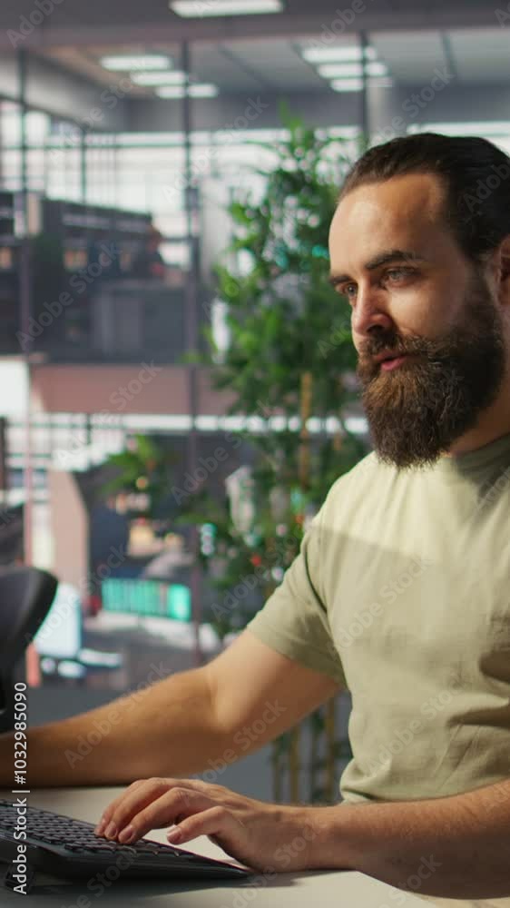 Poster vertical video employee looking at pc monitor, drinking coffee, checking data needed for finding bus