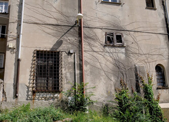 An old abandoned religious building with street lamp and gutter on the wall