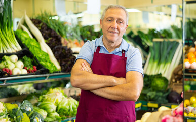 in department of vegetables and fruits, man seller is ready to help buyers choose fresh products
