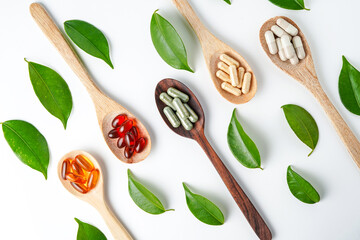 Top view Variety of vitamin and mineral pills in wooden spoon, Dietary supplement healthcare