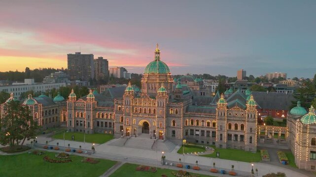 Victoria, British Columbia, Canada. October 05, 2024: Drone perspective of the British Columbia Parliament Building at dusk, illuminated by string lights
