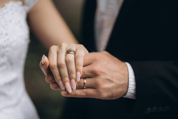 Newly wed couple's hands with wedding rings.